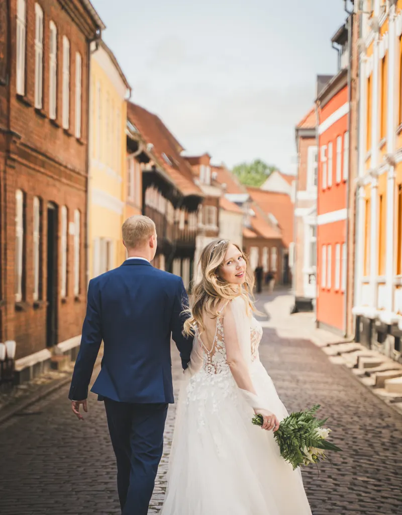 Brautpaar in einer Gasse in Ribe, die Braut schaut zurück